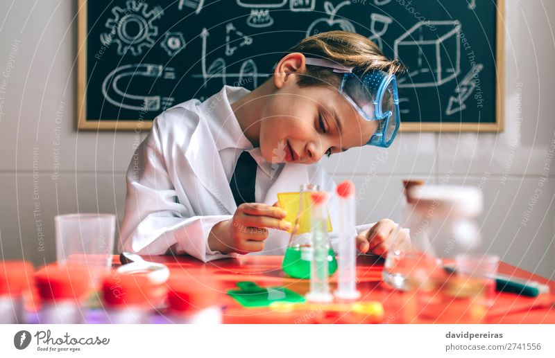 Boy chemist playing with chemistry game in front of blackboard Playing Science & Research Child School Blackboard Laboratory Human being Boy (child) Man Adults