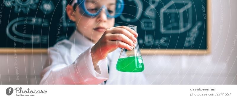 Little boy scientist holding flask with green liquid against of drawn blackboard Bottle Playing Table Science & Research Child Classroom Blackboard Laboratory