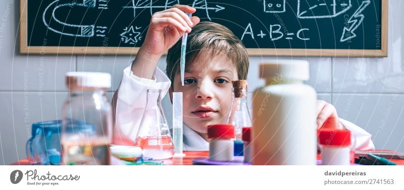 Kid playing with chemical liquids over table Bottle Happy Playing Table Science & Research Child Classroom Blackboard Laboratory Internet Human being