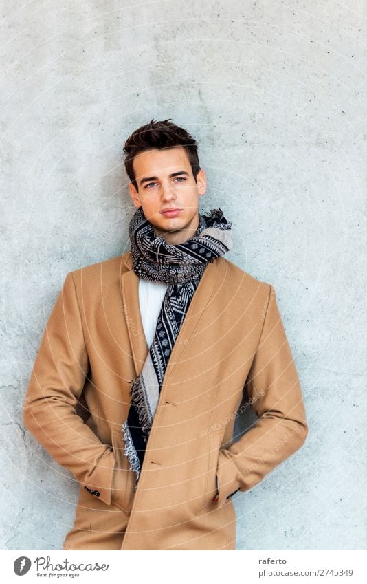 Trendy young man wearing coat and scarf leaning on a wall Lifestyle Elegant Style Beautiful Hair and hairstyles Human being Masculine Young man
