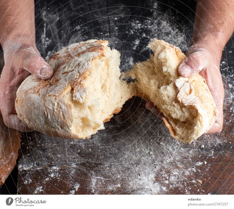 baked bread in half Bread Nutrition Table Kitchen Profession Cook Human being Hand Fingers Wood Make Dark Fresh Hot Brown Black White Tradition Baking Baker
