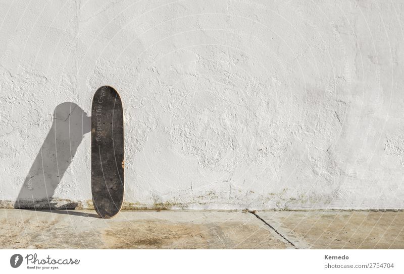 Skateboard on deteriorated white wall during a sunny day. Lifestyle Harmonious Relaxation Leisure and hobbies Ride Adventure Freedom Summer Summer vacation