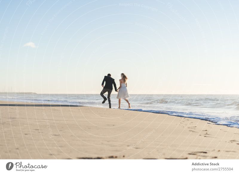 Romantic bride and groom strolling on beach Couple Bride Groom To go for a walk in love Beach romantic Relationship holding hands Dream Youth (Young adults)