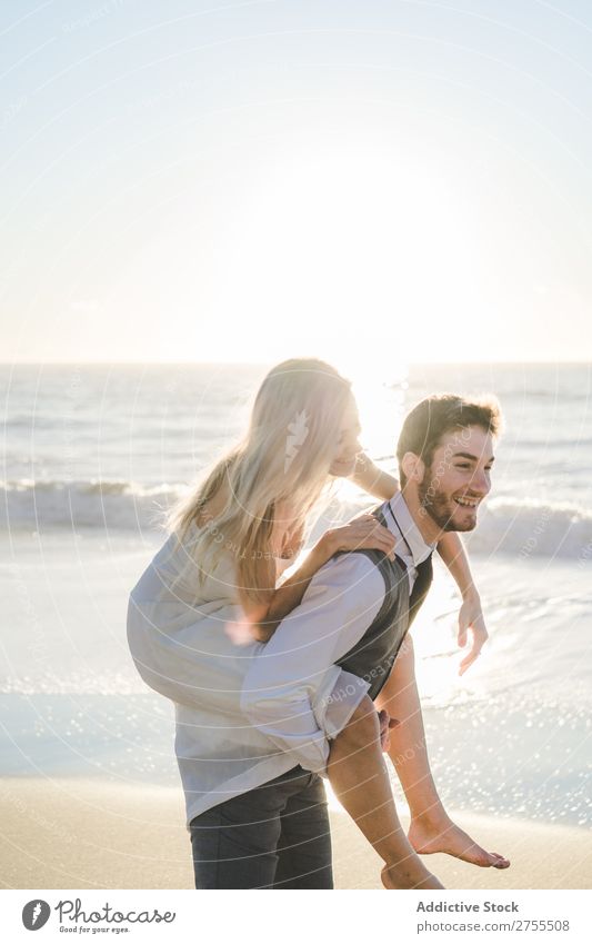 Groom carrying charming girl on back Couple Wedding Beach Summer Ocean in love Bride Carrying Relaxation Laughter Cheerful Dress Beautiful Nature Engagement