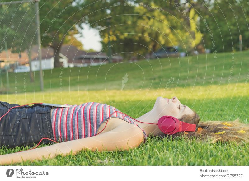 Girl with gadgets on lawn Woman Headphones Relaxation Feminine Music Dream Flower Meadow Entertainment Student Park Summer Freedom Contentment Nature Listening