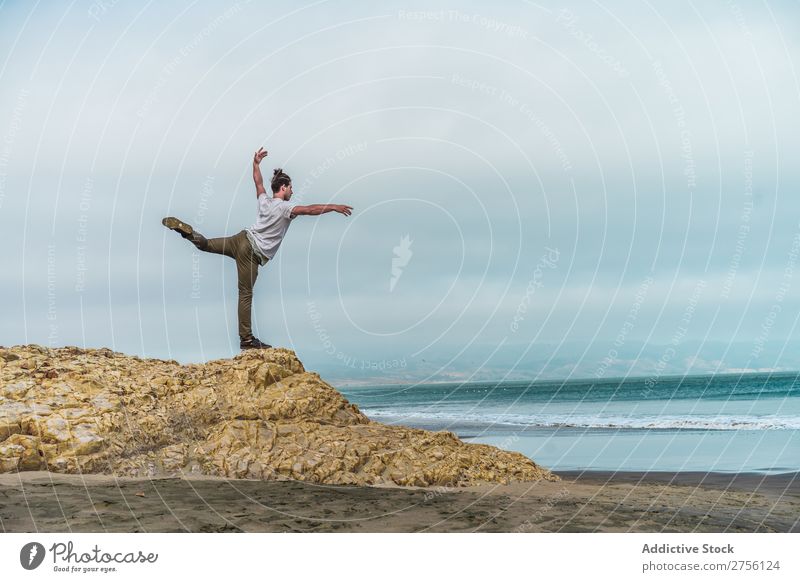 Man balancing on stone at sea Human being Coast Youth (Young adults) Ocean Balance Stone Yoga Meditation Tourist Landscape Vacation & Travel Hill Sand Water