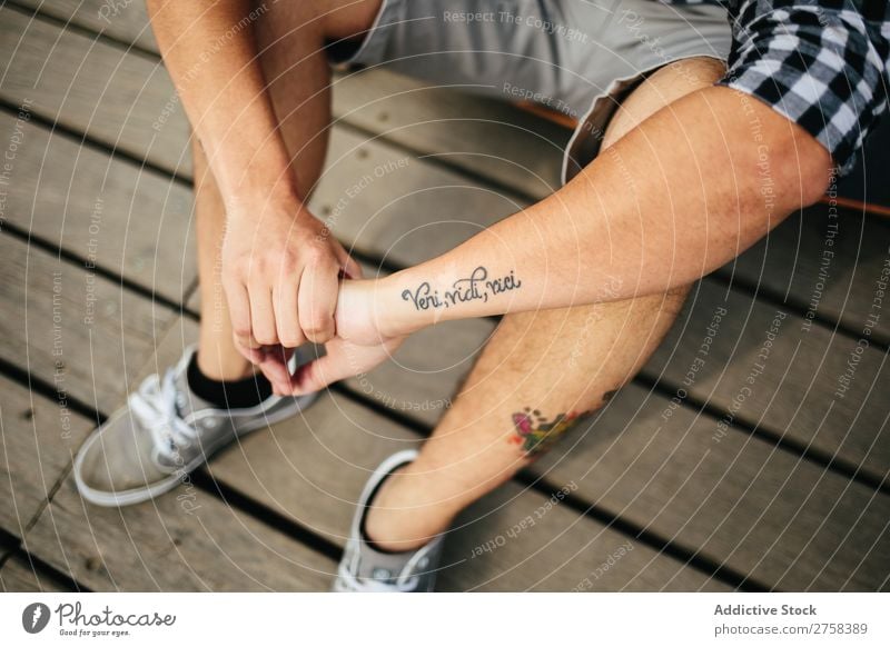Man with tattoos sitting on wooden floor Tattooed Sit Shorts Lifestyle Youth (Young adults) Attractive Sneakers outfit Story Anonymous Unrecognizable Guy