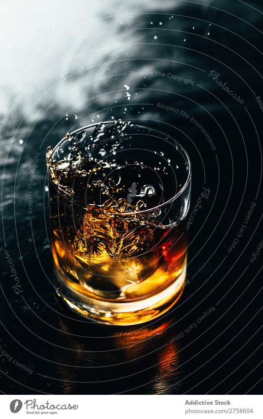 Glass of splashing whiskey Alcoholic drinks Beverage Bourbon Brown Cocktail Cold Cool (slang) Crystal Cube Dark Drinking Drop Elegant Bird's-eye view glassware