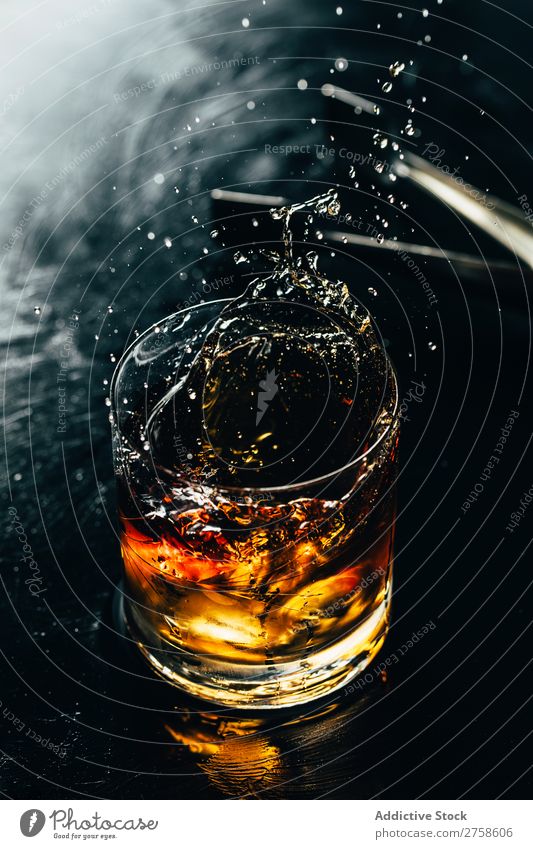 Glass of splashing whiskey Alcoholic drinks Beverage Bourbon Brown Cocktail Cold Cool (slang) Crystal Cube Dark Drinking Drop Elegant Bird's-eye view glassware