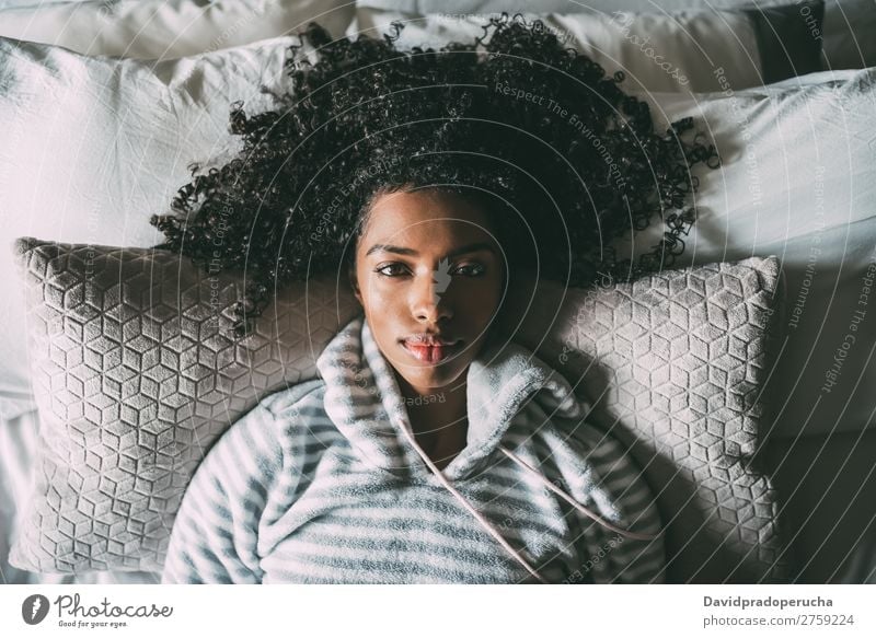Beautiful black woman with curly hair lying on bed looking at the camera Woman Bed Black African pretty Bird's-eye view Close-up Curly hair Interior shot