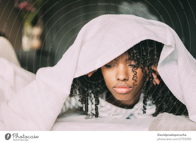 Beautiful serious thoughtful and sad black woman covering her head with sheet in bed Woman Bed Sadness Anger Black worried trouble problems Covered Covering