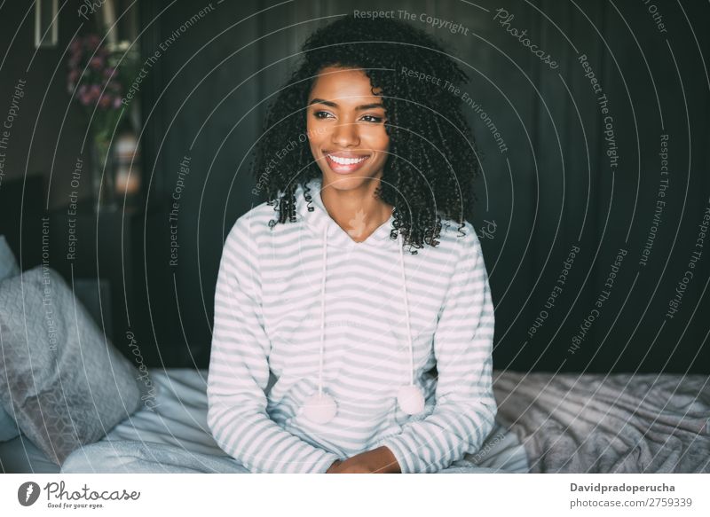 close up of a pretty black woman with curly hair smiling and lying on bed looking away Woman Bed Portrait photograph Close-up Lie (Untruth) Black Smiling