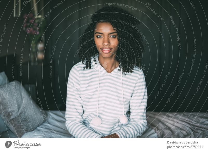 close up of a pretty black woman with curly hair smiling sit on bed looking at the camera Woman Bed Portrait photograph Close-up Sit Black Smiling African