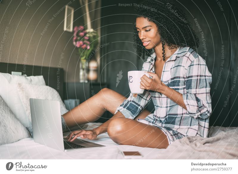 beautiful black woman on bed with laptop and cup of coffee Woman Bed Notebook Computer Smiling Portrait photograph Close-up Technology Internet wifi device