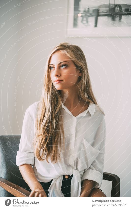 Portrait of a young thoughtful blonde woman sitting Woman Sit Portrait photograph Room Smiling Youth (Young adults) Considerate pretty Close-up Life Home Happy