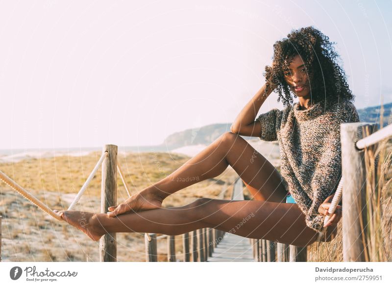 Beautiful young black woman sitting in a  wooden foot bridge at the beach Background picture Beach Bikini Black Bridge Coast Curly hair Destination Feet Hair