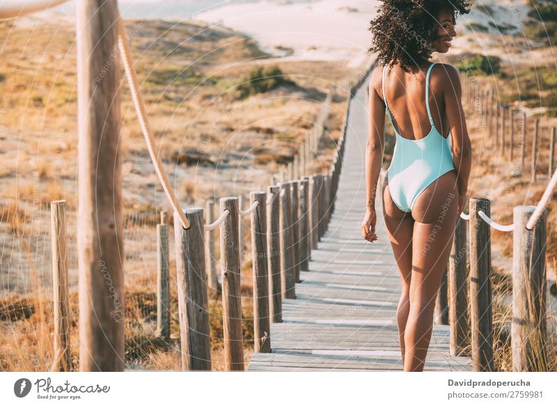Young woman with a swimming suit walking in a wooden foot bridge at the beach Beach Woman Bikini Swimming Suit Black Bridge Background picture Coast Curly hair
