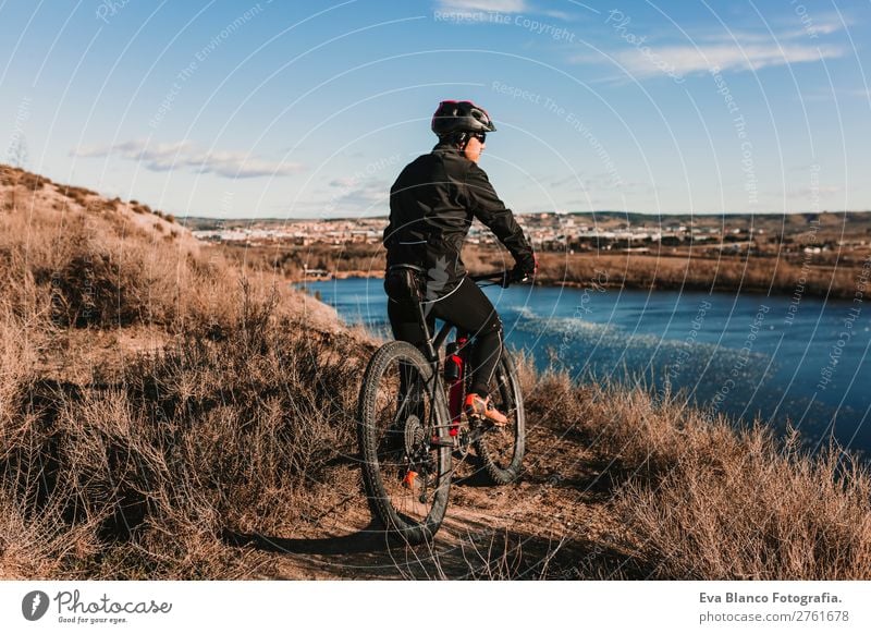 Cyclist Riding a Bike at sunset. Sports Lifestyle Relaxation Leisure and hobbies Trip Adventure Summer Sun Mountain Cycling Bicycle Masculine Young man