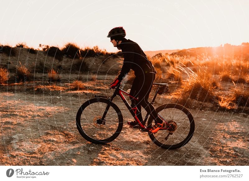 Cyclist Riding a bike at sunset. Sports Lifestyle Relaxation Leisure and hobbies Adventure Summer Sun Mountain Cycling Bicycle Masculine Young man