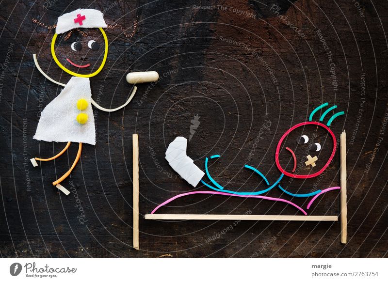 Gummy worms: Get well soon! A nurse comes with a big syringe. The patient  is lying in bed with a broken leg and a plaster on his face - a Royalty Free