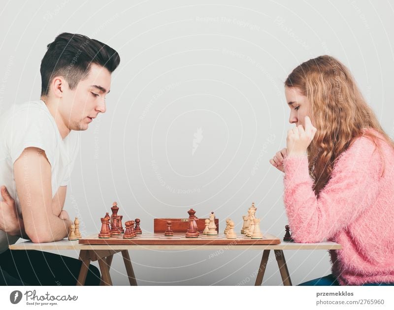 Girl and boy playing chess at home Lifestyle Leisure and hobbies Playing Chess Success Human being Boy (child) Woman Adults Man To enjoy Smart Black White