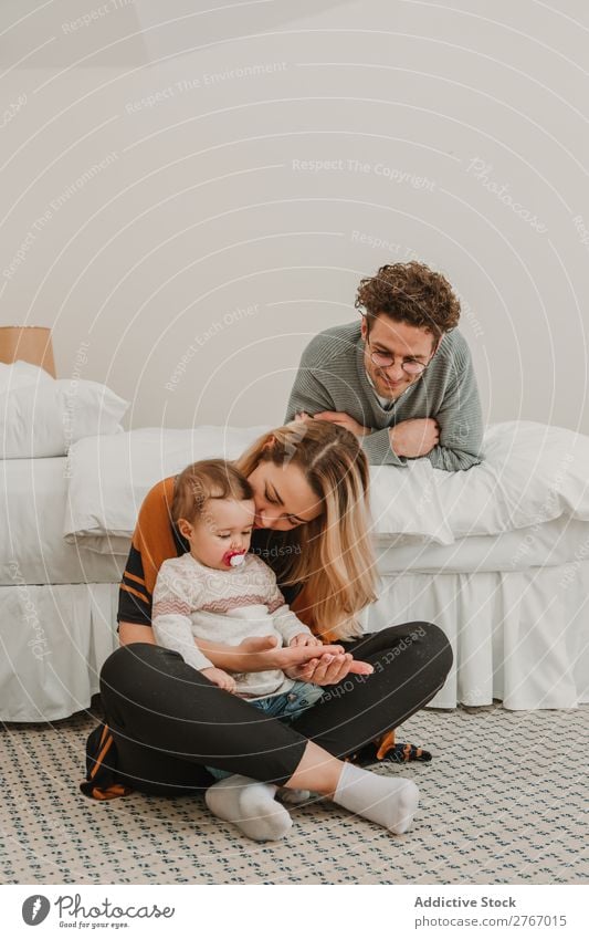 Cheerful couple with child on bed Family & Relations Mother Father Child Playing Human being Hotel Room Bedroom Home Interior design Furniture Flat (apartment)