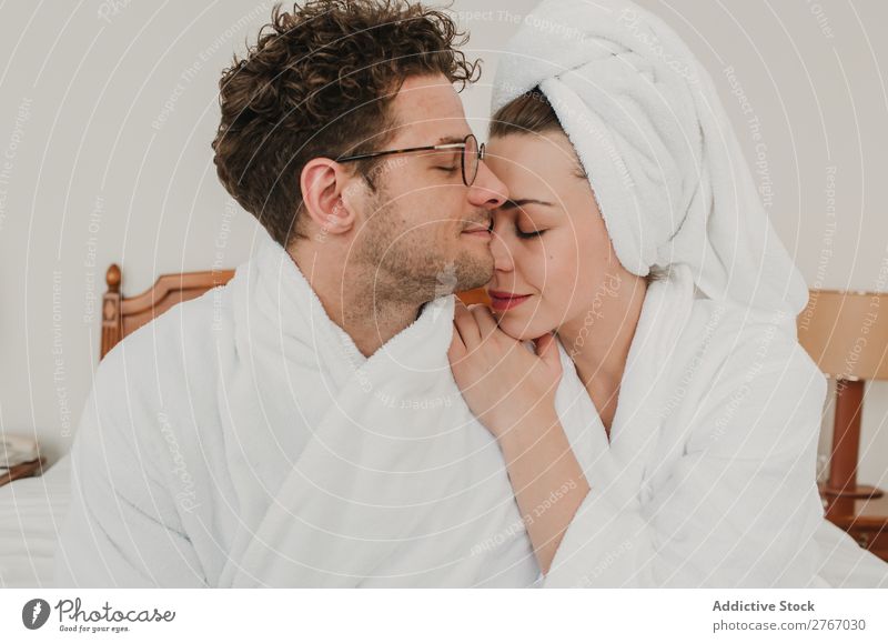 Happy couple embracing on bed Couple Bathrobe Cuddling eyes closed Hotel Room Bedroom Home Interior design Furniture Flat (apartment) Design Comfortable