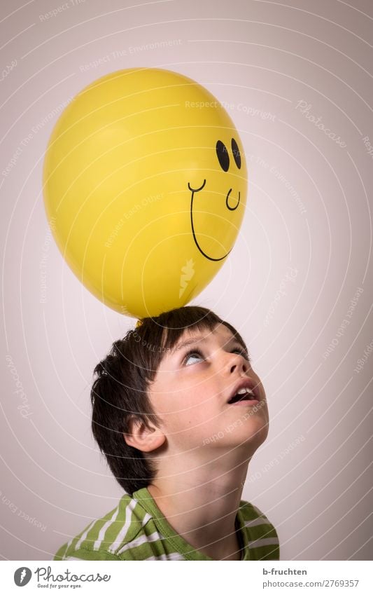 Child with balloon Leisure and hobbies Head Face 1 Human being Sign Select Observe Touch Throw Simple Elegant Happiness Yellow Balloon Laughter Smiley Looking