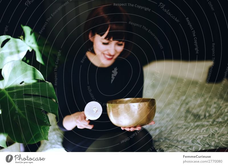 Mindfulness - Woman with singing bowl in her cozy home Healthy Life Harmonious Well-being Contentment Senses Relaxation Calm Meditation Feminine Adults 1
