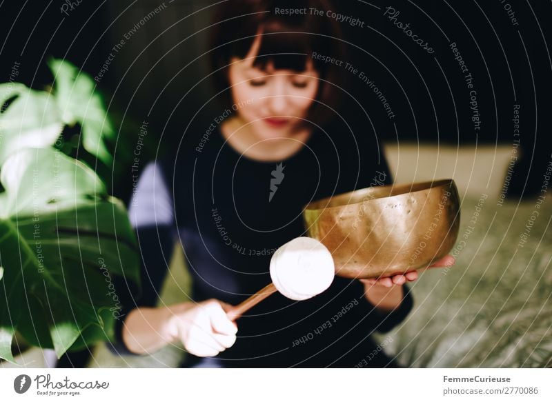 Mindfulness - Woman with singing bowl in her cozy home Harmonious Well-being Contentment Senses Relaxation Calm Meditation Feminine Adults 1 Human being