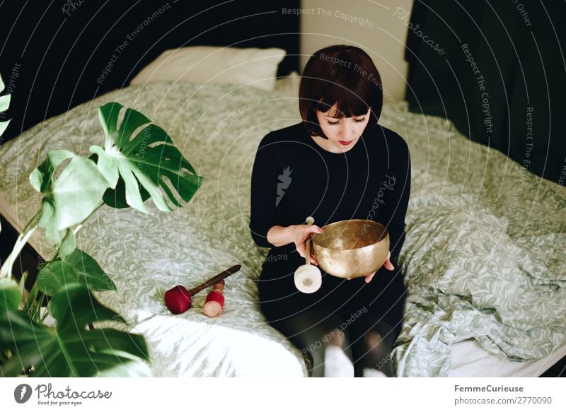 Mindfulness - Woman with singing bowl in her cozy home Harmonious Well-being Contentment Senses Relaxation Calm Meditation Feminine Adults 1 Human being