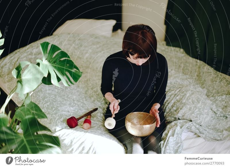Mindfulness - Woman with singing bowl in her cozy home Healthy Harmonious Well-being Contentment Senses Relaxation Calm Meditation Feminine Adults 1 Human being
