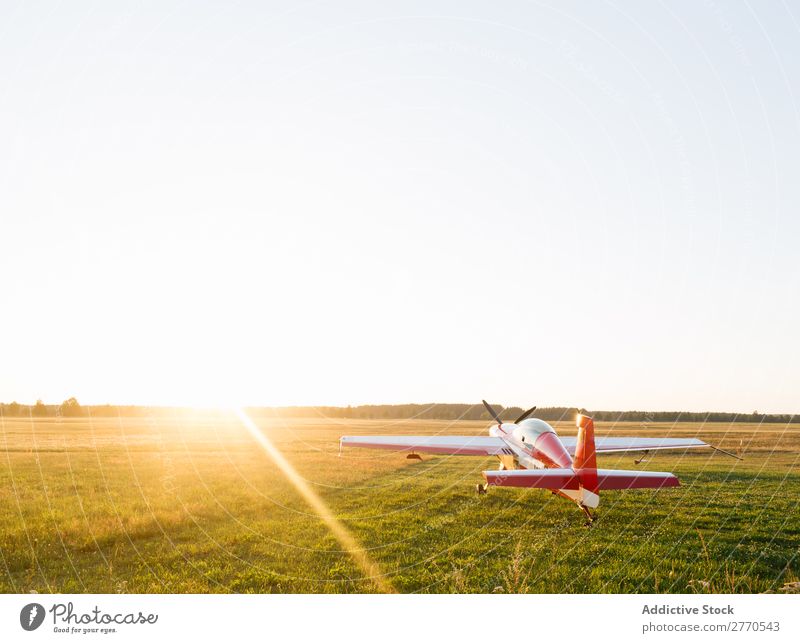 Shiny red airplane in green field Airplane Airfield Summer Transport Vacation & Travel Story Sunlight aerodrome Tourism Trip Glittering Technology Departure