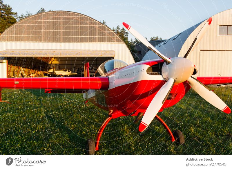 Shiny red airplane in green field Airplane Airfield Summer Transport Vacation & Travel Story Sunlight aerodrome Tourism Trip Glittering Technology Departure