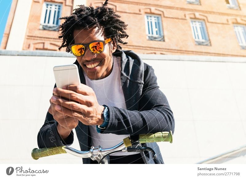 Afro young man using mobile phone and fixed gear bicycle. Man Youth (Young adults) African Black mulatto Mobile Bicycle fixie Telephone Lifestyle Stand Cycling