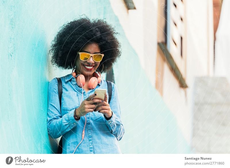 Beautiful afro american woman using mobile in the street. Woman Black African Afro Human being Portrait photograph PDA Youth (Young adults) Mobile Telephone