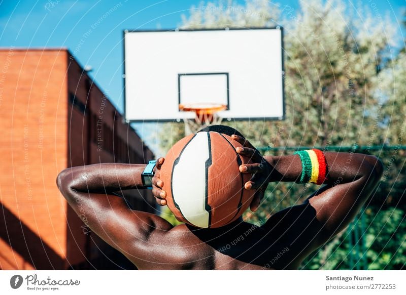 Male basketball player holding a ball. Action African-American Back Rear view Ball Basket Basketball Black City City life Court building Day Practice Playing