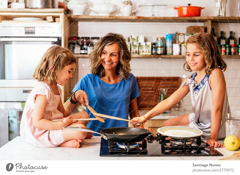 Little sisters cooking with her mother in the kitchen. Mother Child Girl Cooking Kitchen Chocolate Ice cream Daughter Day Happy Joy Family & Relations Love