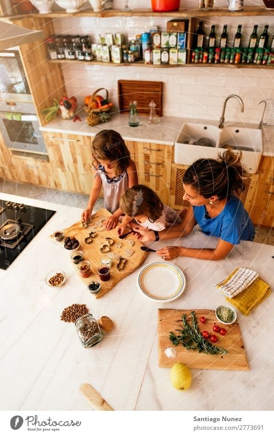 Little sisters cooking with her mother in the kitchen. Mother Child Girl Cooking Kitchen Chocolate Jam Strawberry Daughter Spread Day Happy Joy