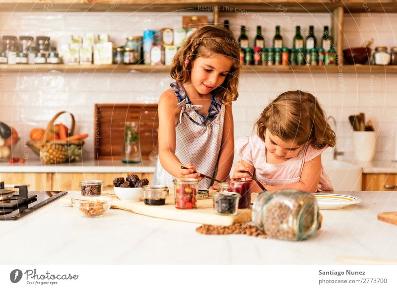 Little sisters girl preparing baking cookies. Girl Child Nutrition Portrait photograph Cooking Kitchen Appetite Preparation Make Smiling Laughter Lunch Baby