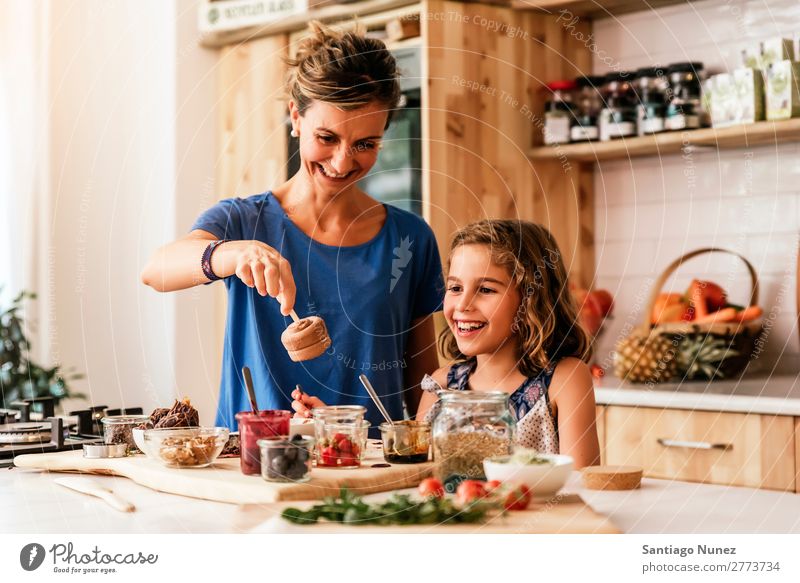 Little girl cooking with her mother in the kitchen. Mother Girl Cooking Kitchen Chocolate Ice cream Daughter Day Happy Joy Family & Relations Love Baking Food