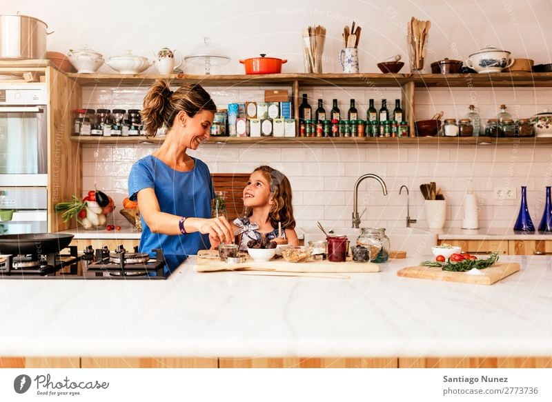 Little girl cooking with her mother in the kitchen. Mother Girl Cooking Kitchen Chocolate Ice cream Daughter Day Happy Joy Family & Relations Love Baking Food