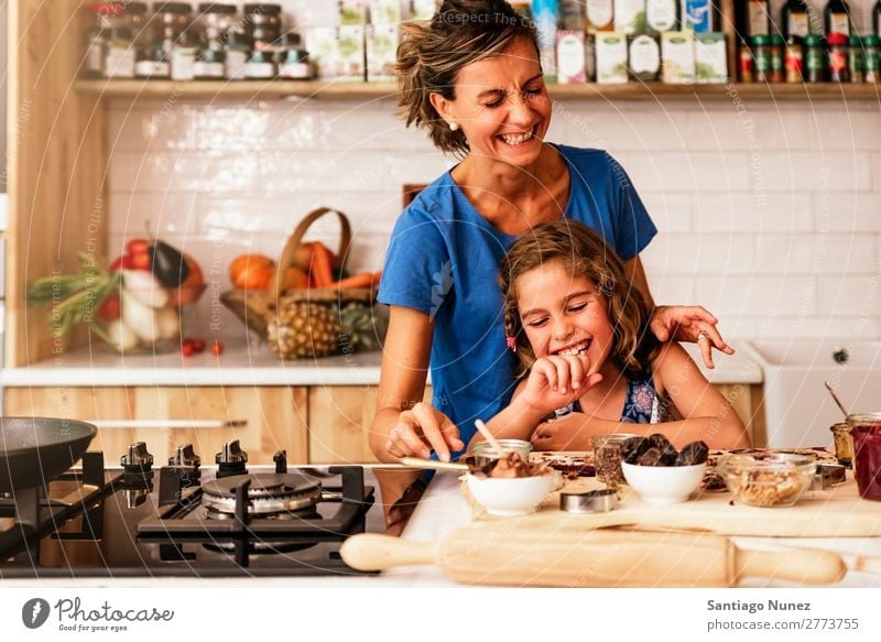 Little girl cooking with her mother in the kitchen. Mother Girl Cooking Kitchen Chocolate Ice cream Daughter Day Happy Joy Family & Relations Love Baking Food