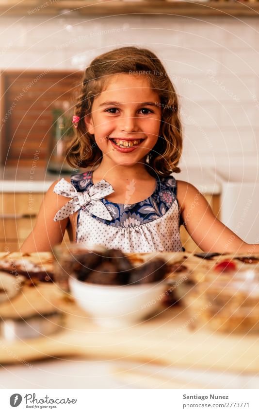 Portrait of little girl preparing baking cookies. Girl Child Nutrition Chocolate To feed savoring Eating enjoying Portrait photograph Appetite Smiling Laughter