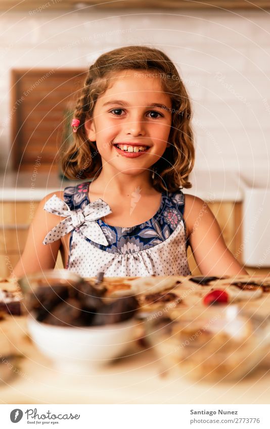 Portrait of little girl preparing baking cookies. Girl Child Nutrition To feed savoring Eating enjoying Portrait photograph Appetite Smiling Laughter Lunch Baby