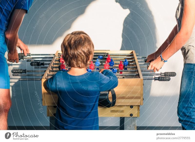Young teenager boy playing table football with another player. Lifestyle Joy Relaxation Leisure and hobbies Playing Summer Table Sports Soccer Boy (child) Man