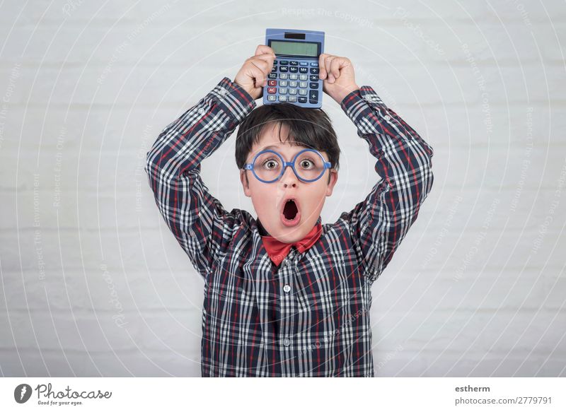 Happy student showing calculator over his head against brick background Lifestyle Joy Child School Study Schoolchild Financial Industry Technology Human being