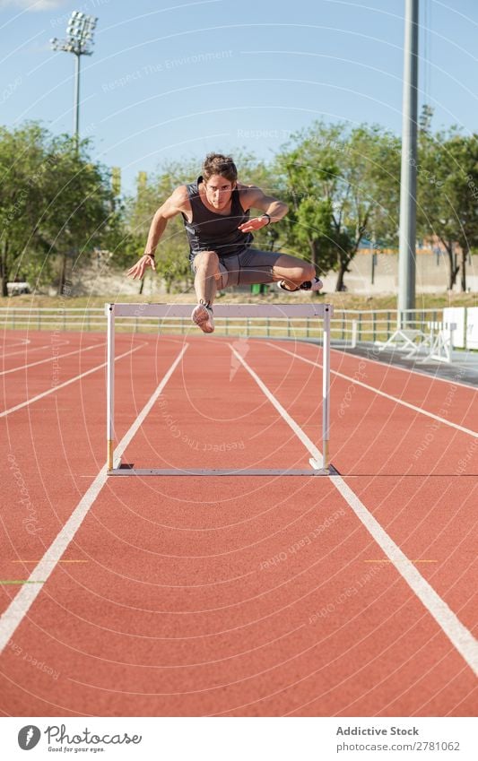 Sportsman jumping over a hurdle sportsman Posture Stadium Stand Fitness Athlete Racecourse Practice Plank Man Muscular Health care Adults Sprinter Athletic