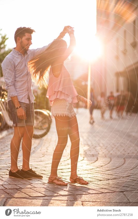 Girlfriend with flying hair dancing in the street holding her boyfriend's hand Couple Dance Street Romance romantic Sunlight Bright backlit Hold Arm Movement