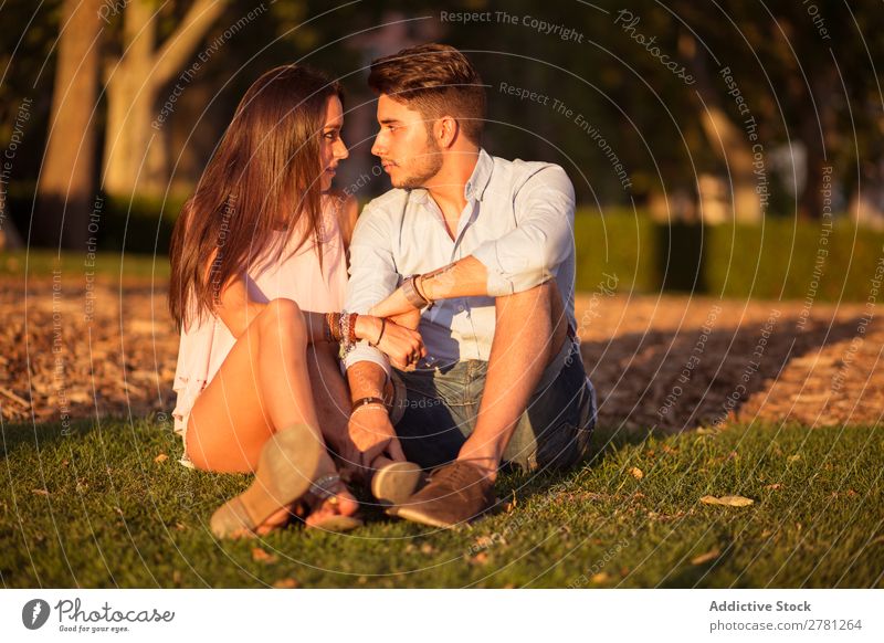 Girlfriend sitting face to face with boyfriend at park Stock Photo